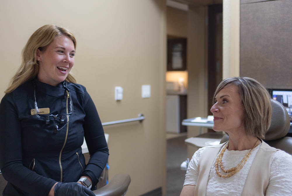 a female dental staff chats up a patient of Oak Park Dental