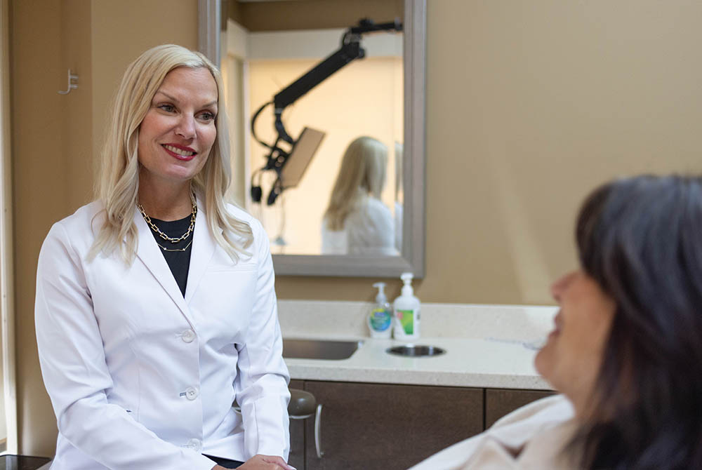 Dr. Jana Gyurina talks to a patient on the dental chair of Oak Park Dental